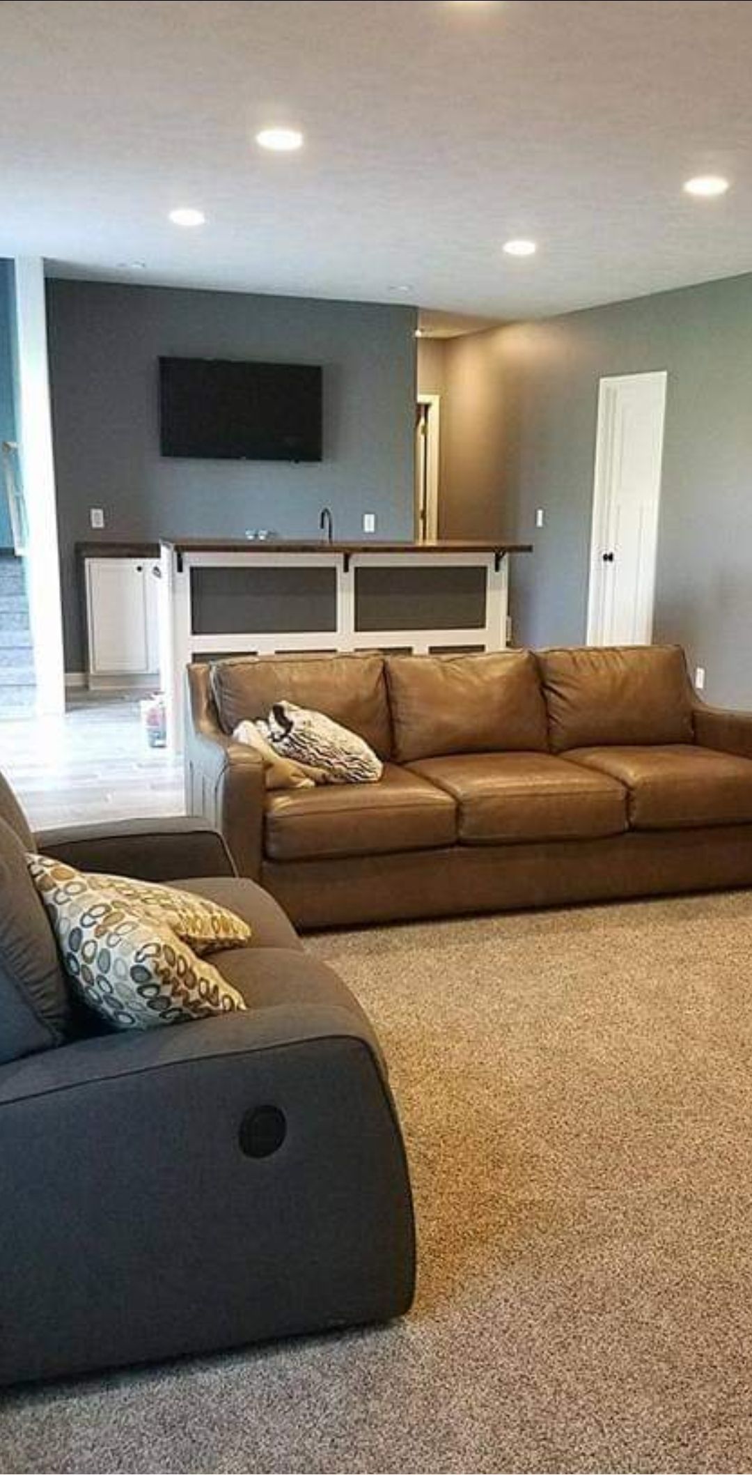 A living room with a couch , chair , and television.