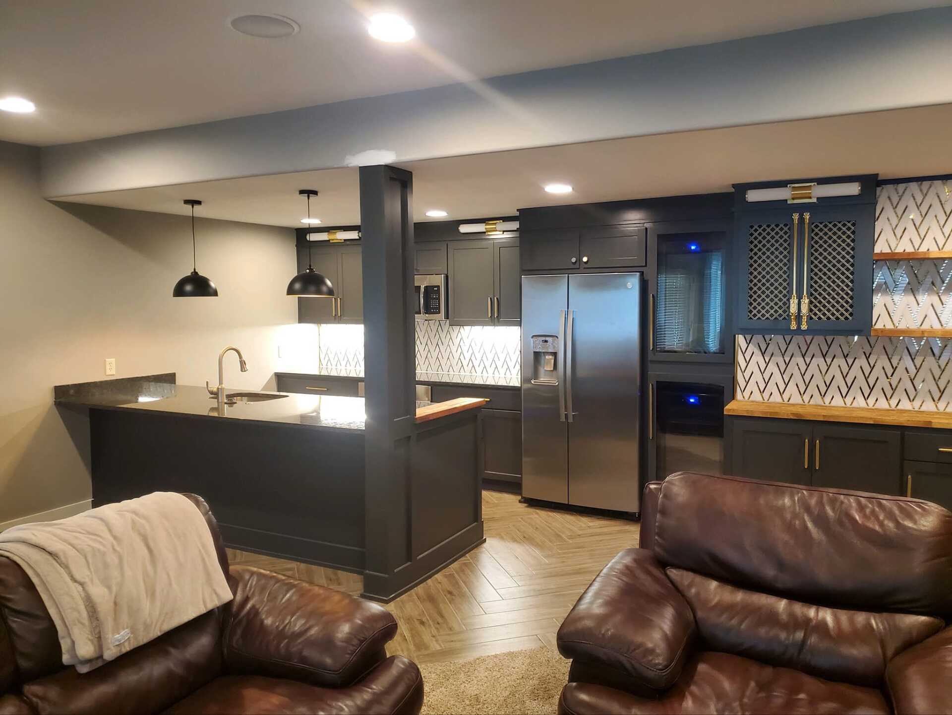 A living room filled with furniture and a kitchen with stainless steel appliances.