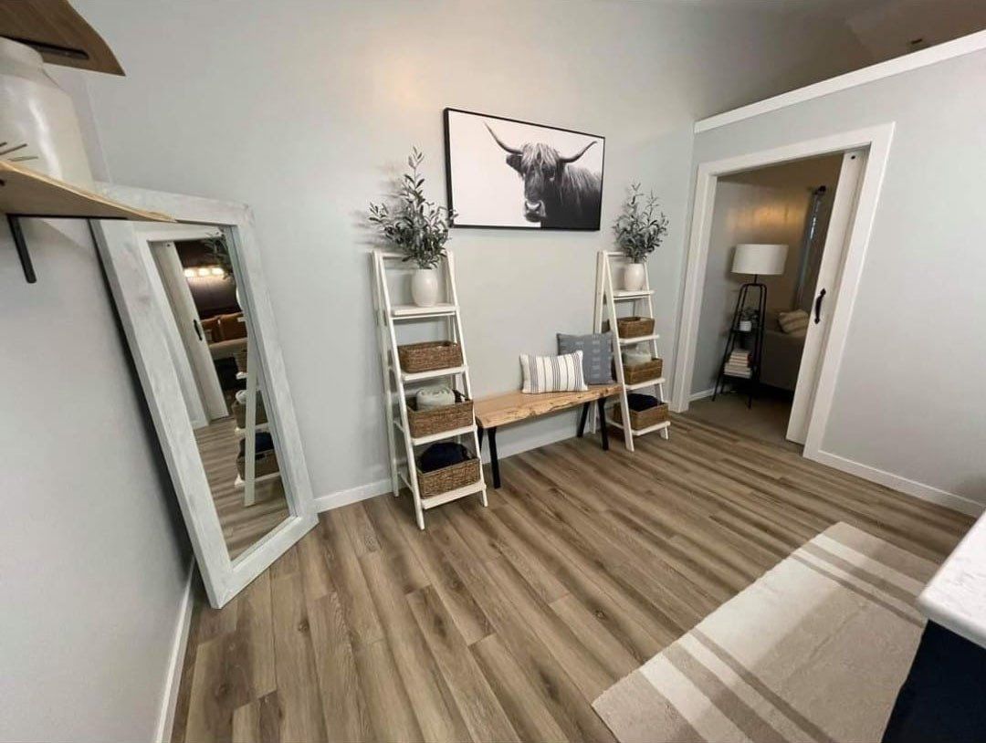 An empty basement room with a brick wall and a black door.