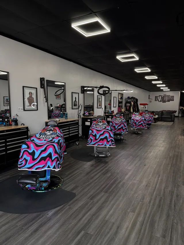 Modern barbershop interior with rows of colorful chairs and mirrors under bright ceiling lights