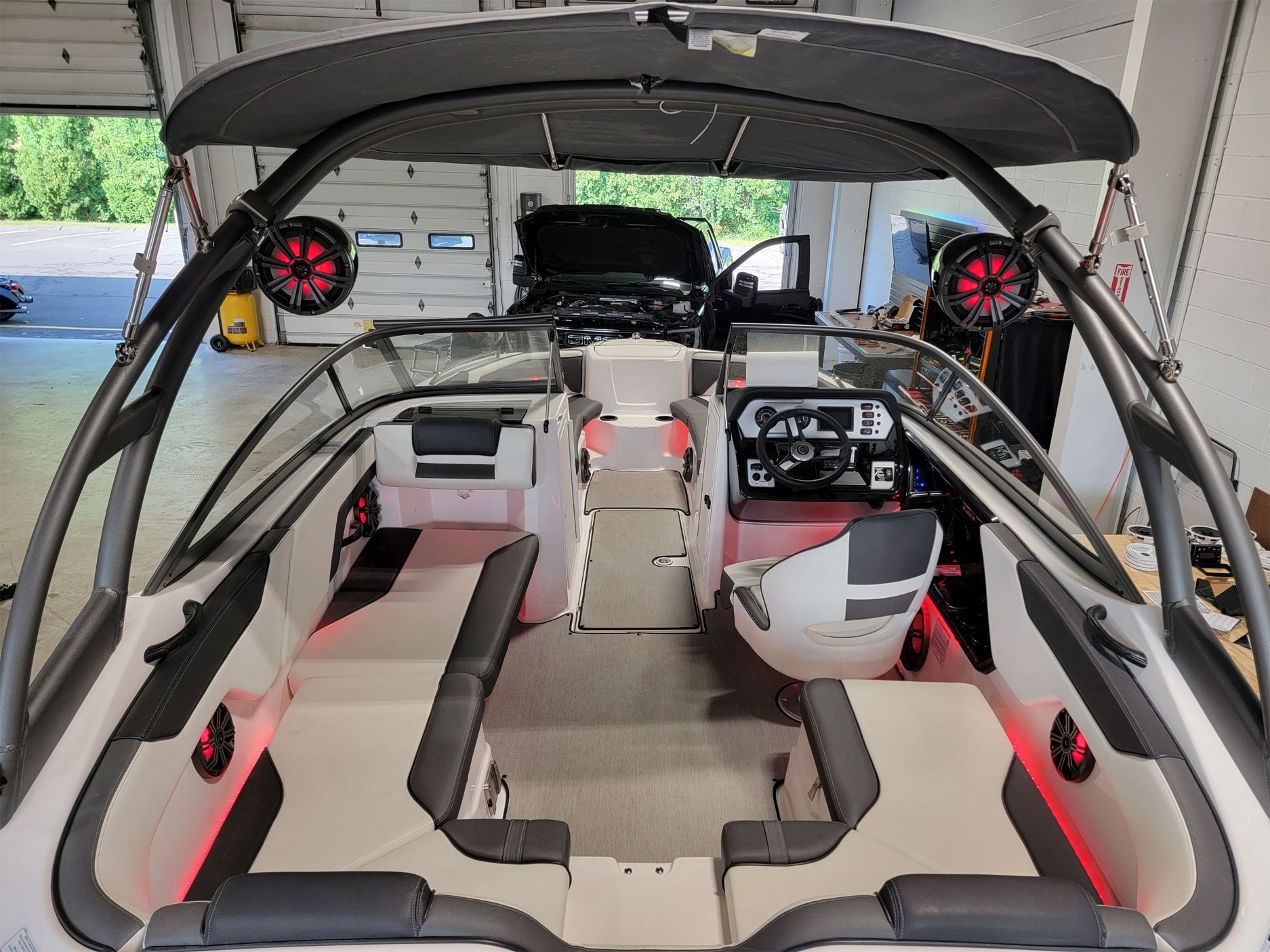 The inside of a boat is sitting in a garage.