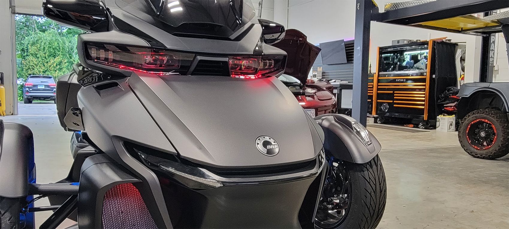 A three wheeled motorcycle is parked in a garage.