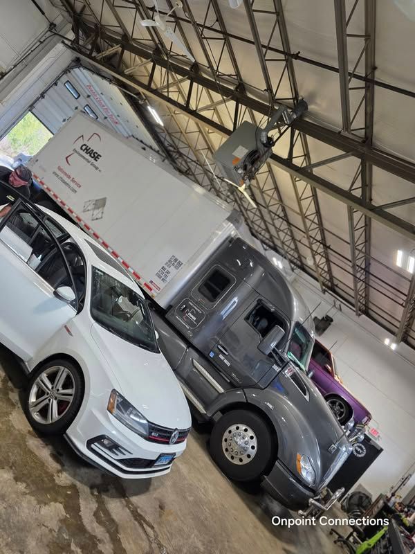A truck and a car are parked in a garage.