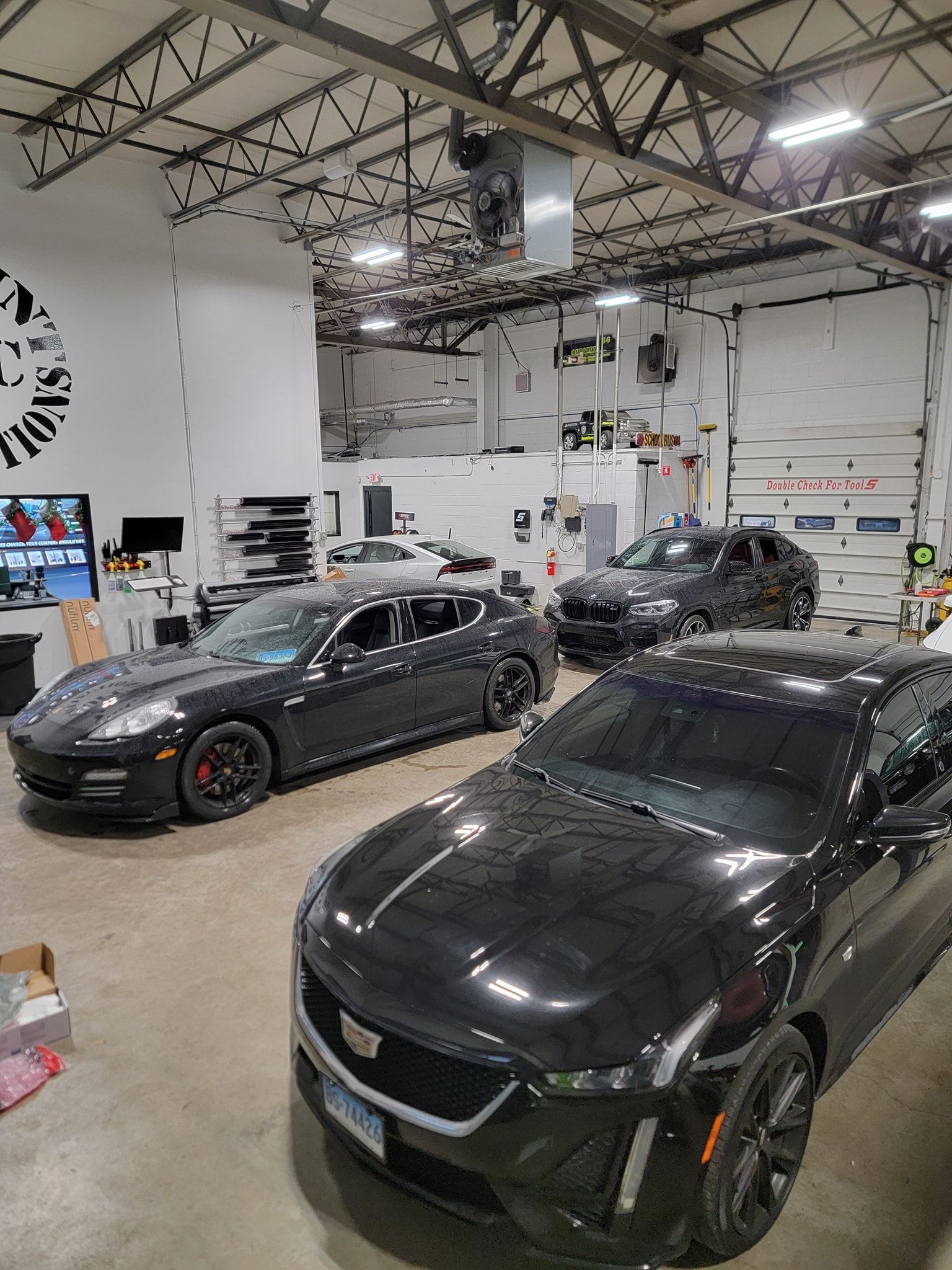 Two black cars are parked in a garage.