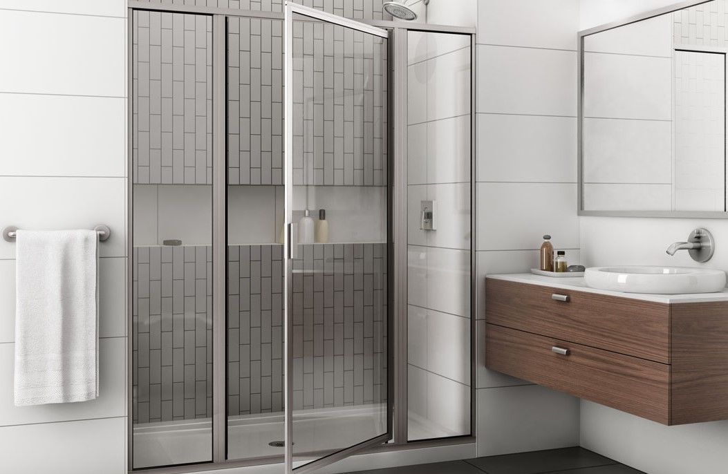 Bathroom with glass shower door, white tile, towel, and wooden vanity.