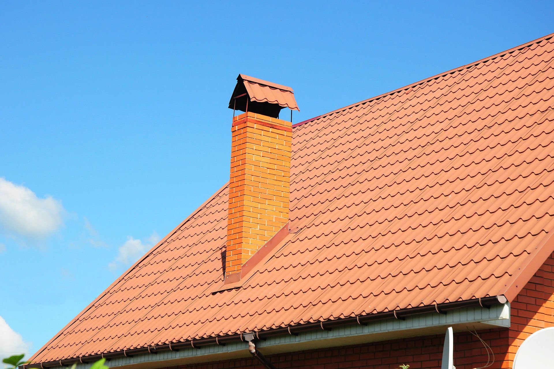 A brick chimney on the roof of a house