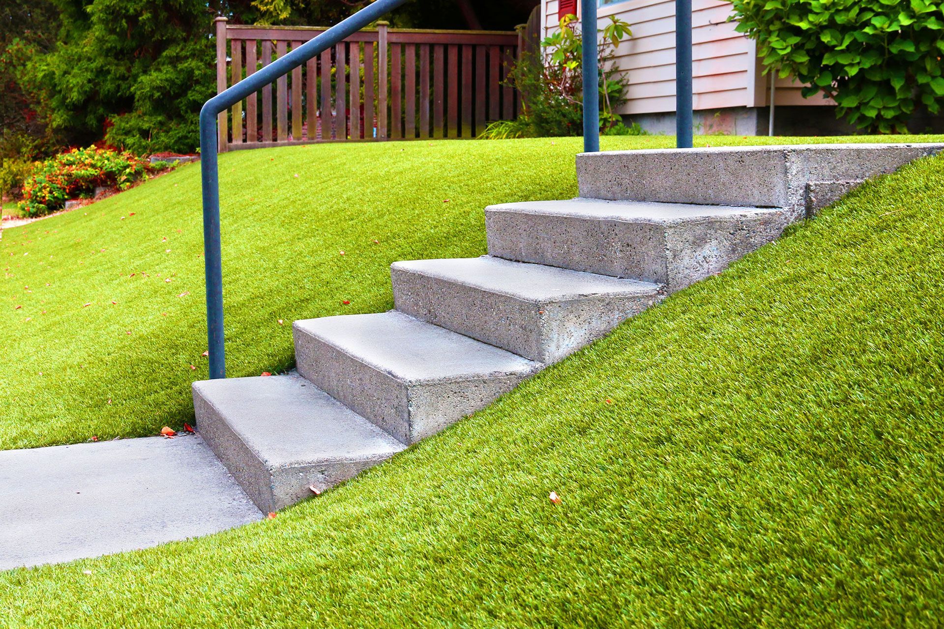 a set of stairs leading up to a house on a grassy hillside