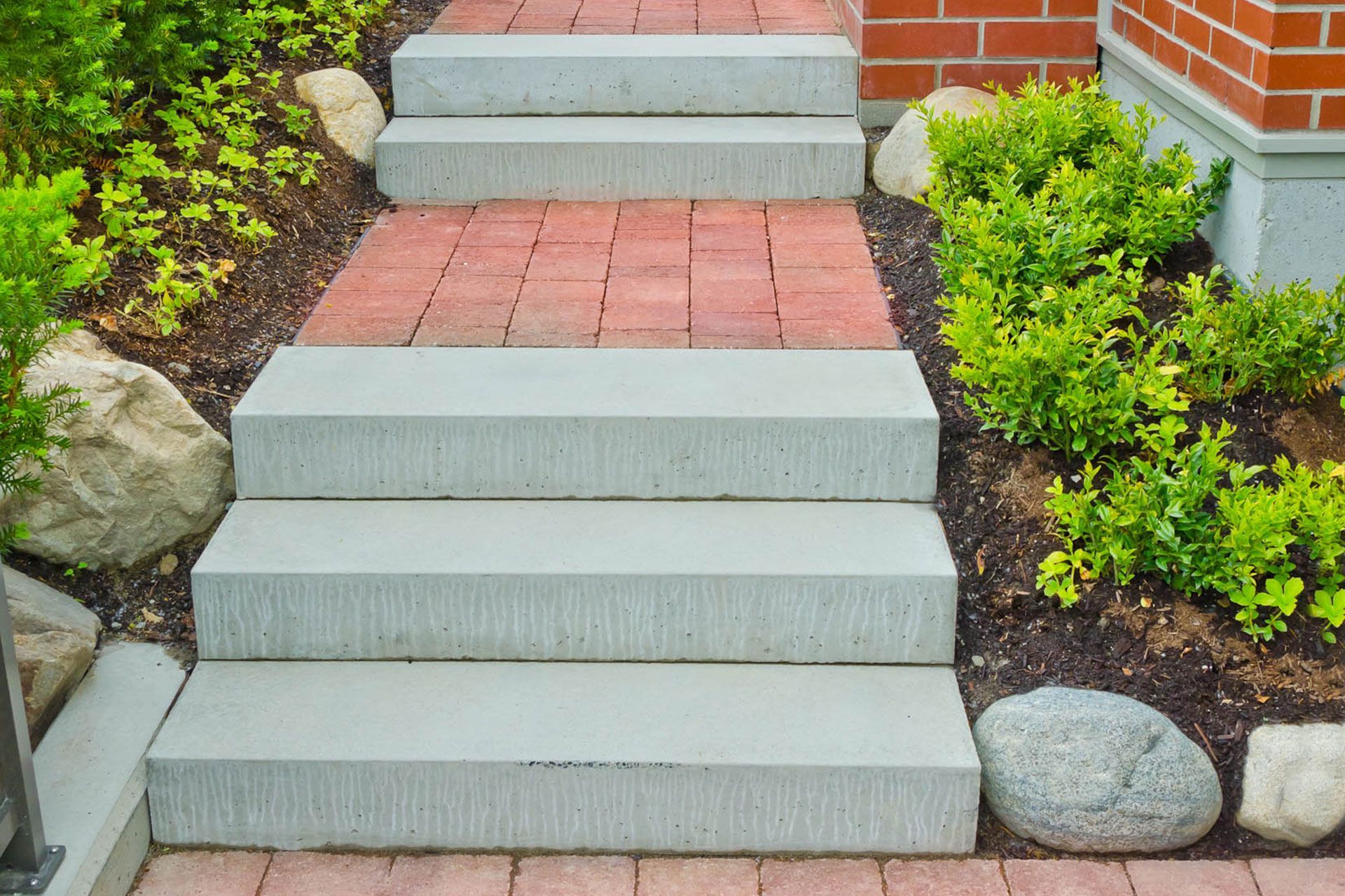 a set of concrete steps leading up to a brick walkway