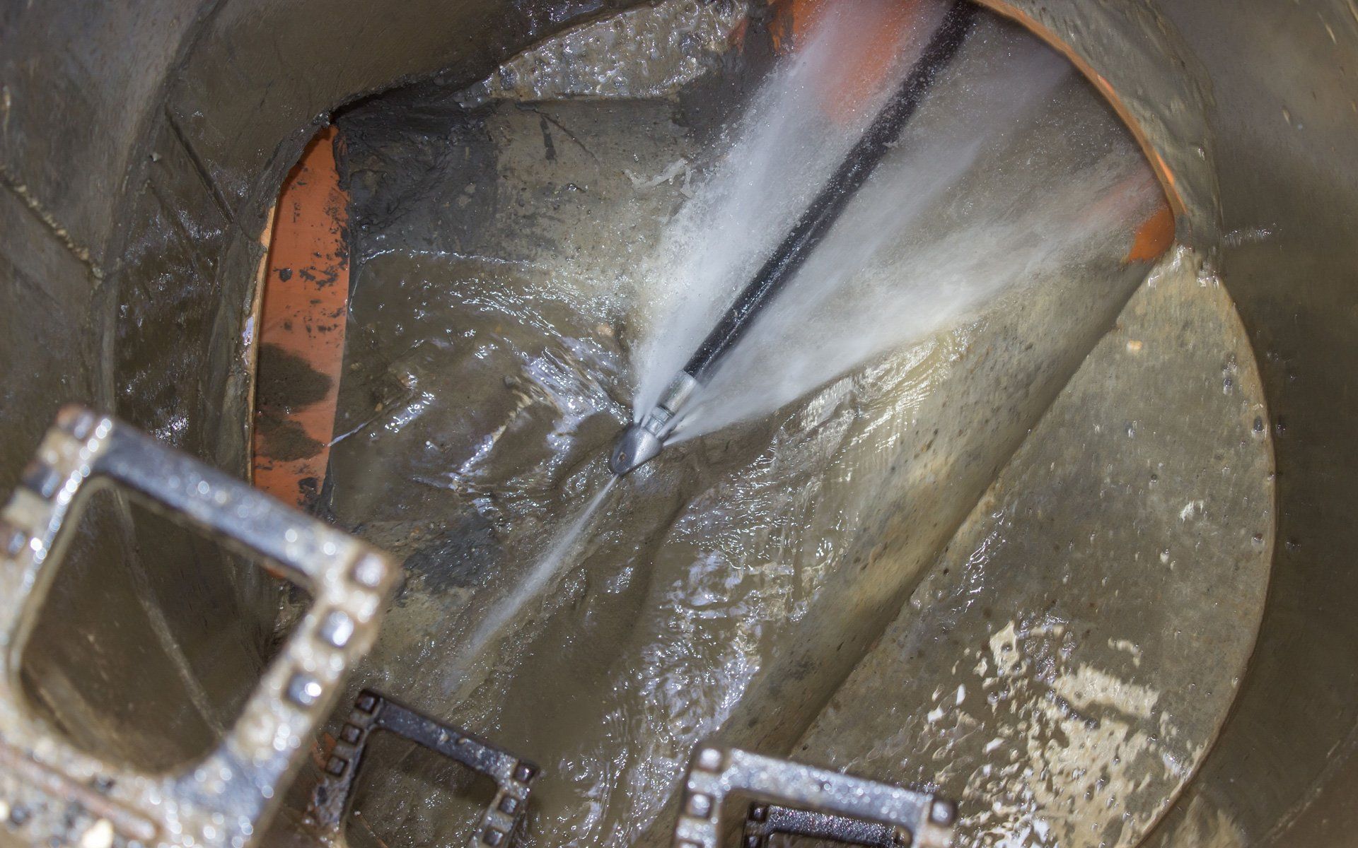 A hose is being used to clean a drain.