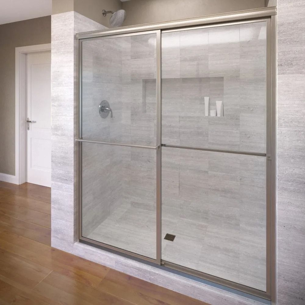 A modern walk-in shower with clear glass sliding doors and brushed metal framing, set against gray tiled walls.