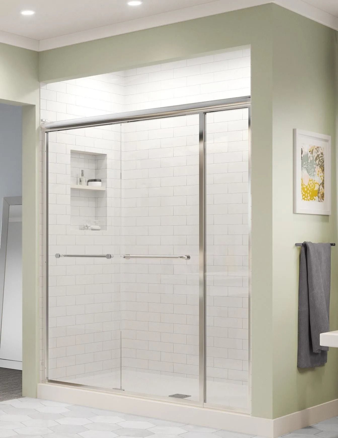 A modern shower featuring glass sliding doors, white subway tile walls with a built-in niche, and soft green bathroom walls.