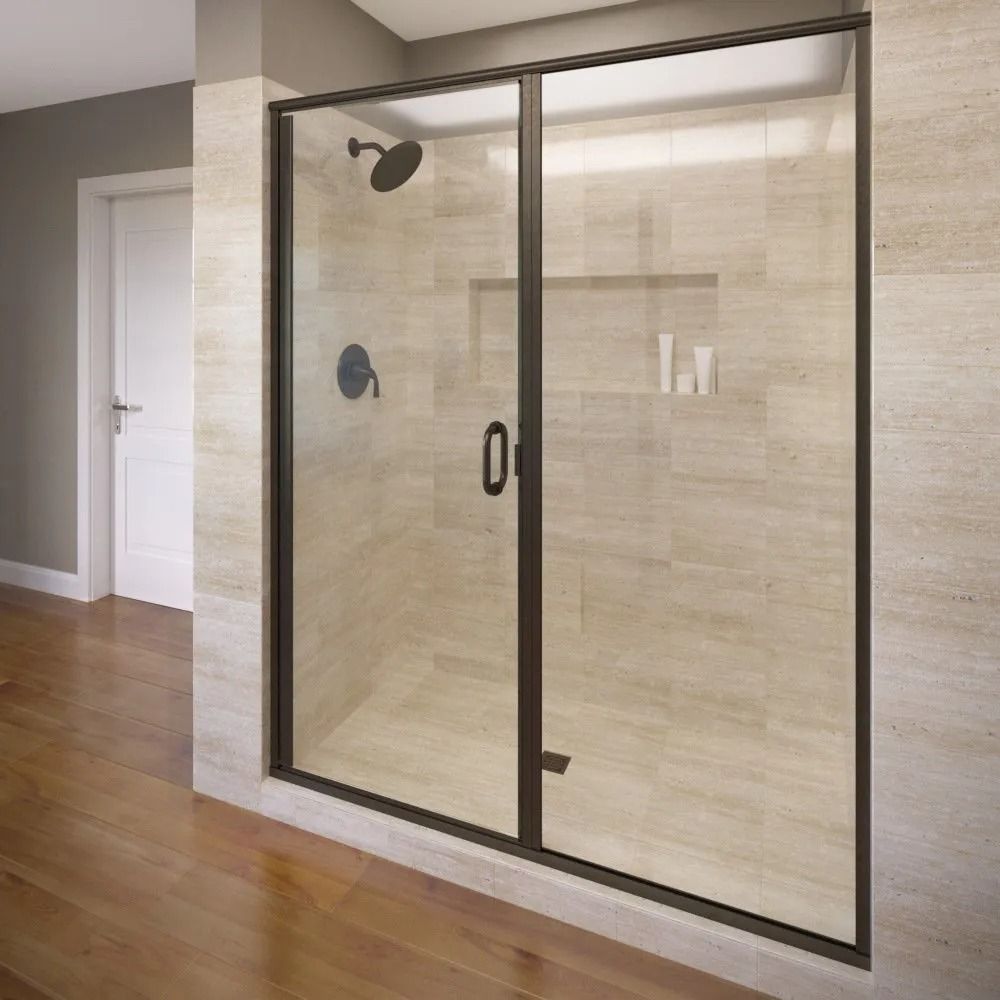 A modern shower enclosure with a dark bronze frame and a glass door installed in a room with light beige tiled walls.