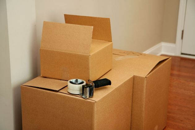 Cardboard boxes stacked, ready for moving with a tape dispenser.
