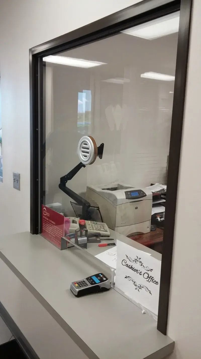 A window in a room with a desk and a printer.