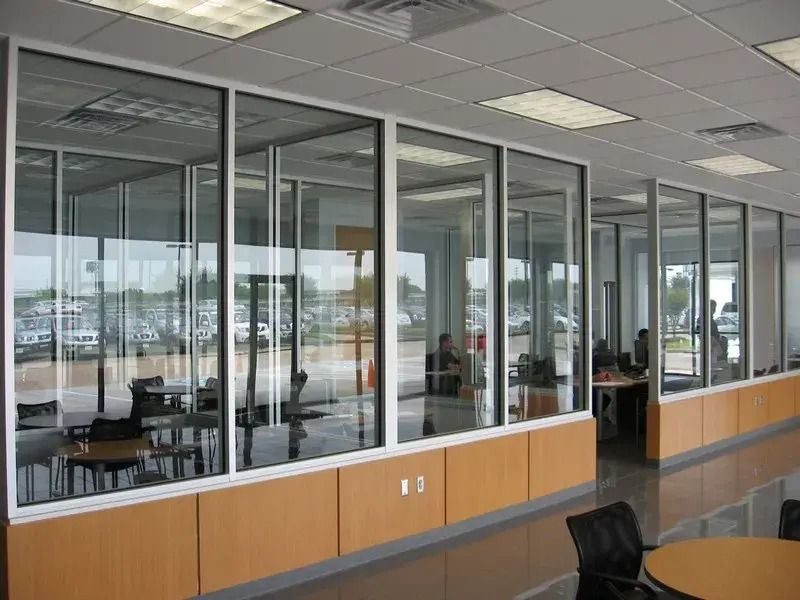 A long hallway with tables and chairs and lots of windows