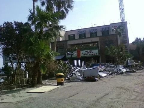 A large building with a lot of trash in front of it.