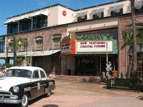 A police car is parked in front of landry's restaurant.