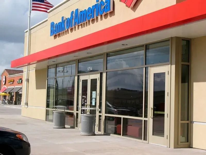 A bank of america building with a car parked in front of it.