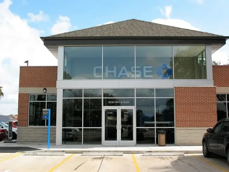 A chase bank with cars parked in front of it.