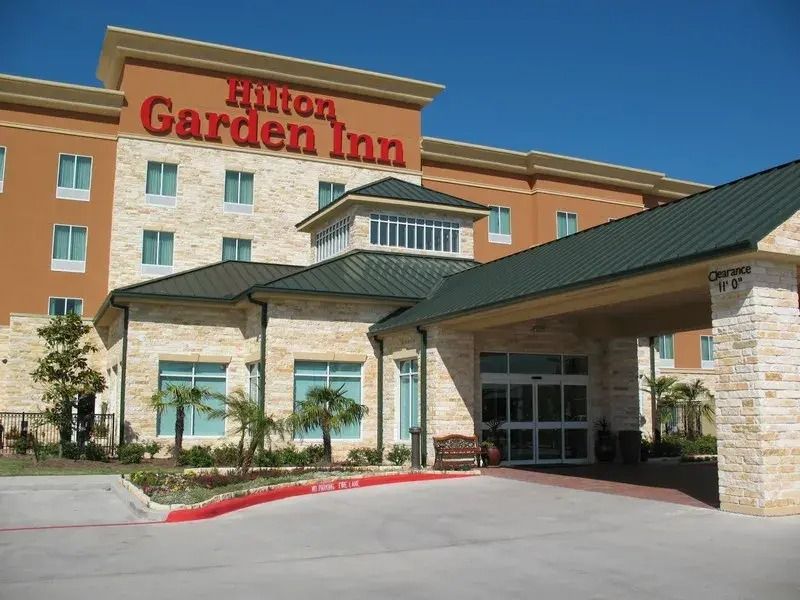 A large hilton garden inn building with a green roof.