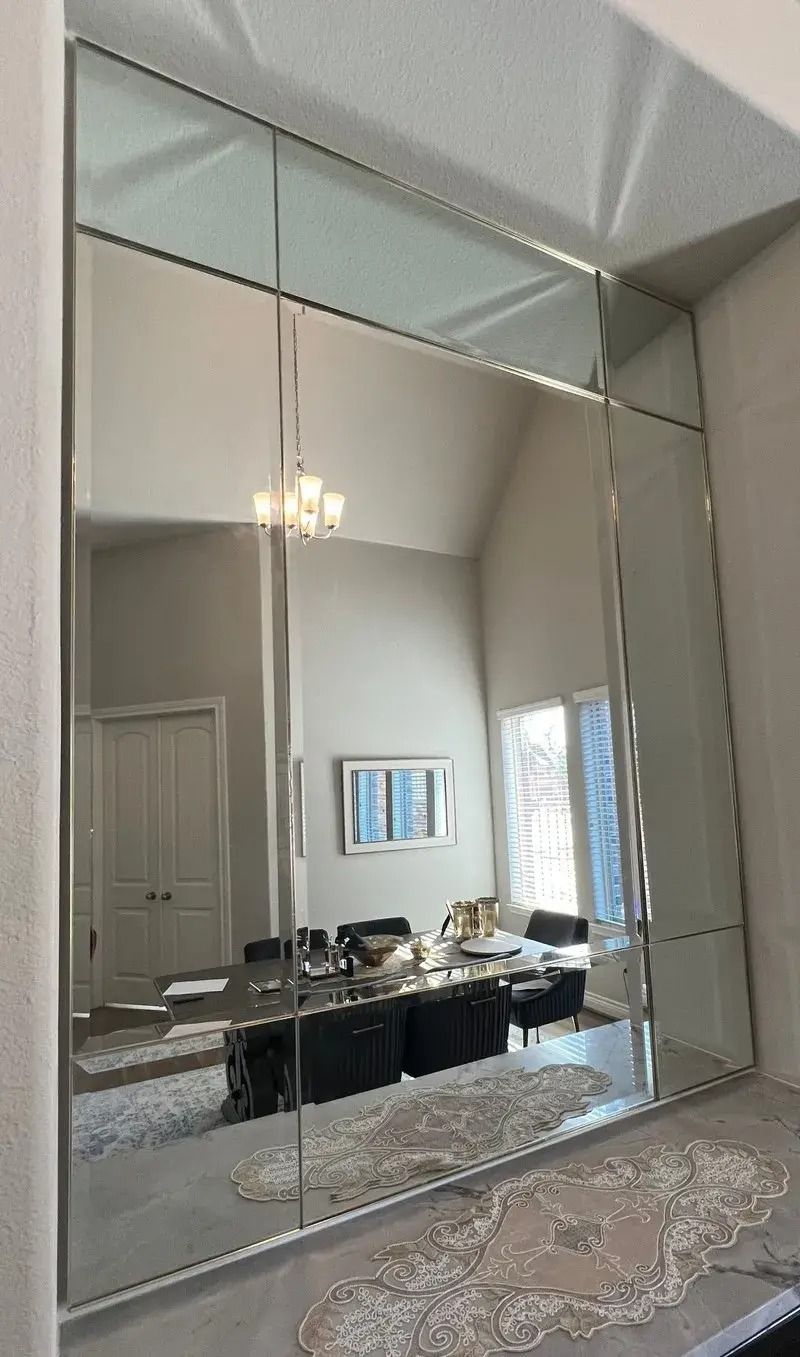 A large mirror is hanging on a wall in a living room.