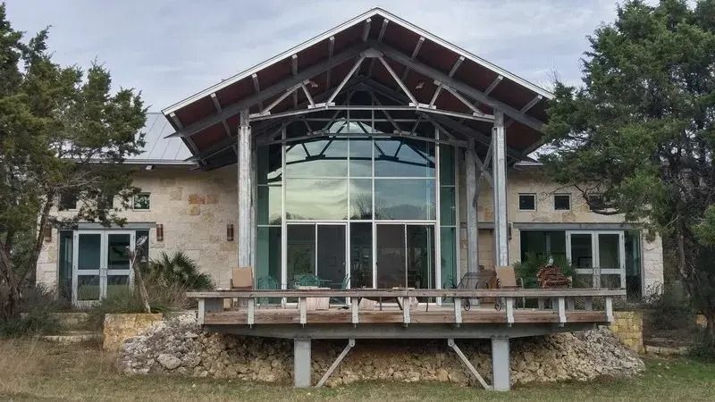 A large house with a lot of windows and trees in the background