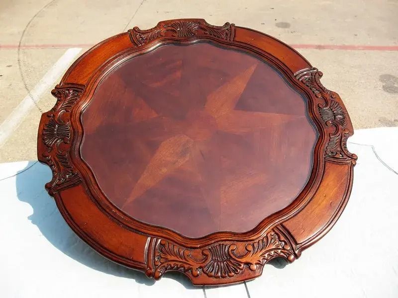 A round mirror with a wooden frame is sitting on the ground