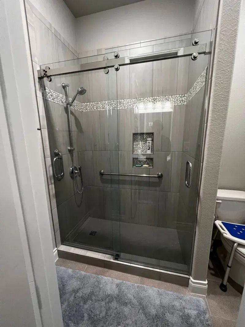 A bathroom with a sliding glass shower door and a toilet.
