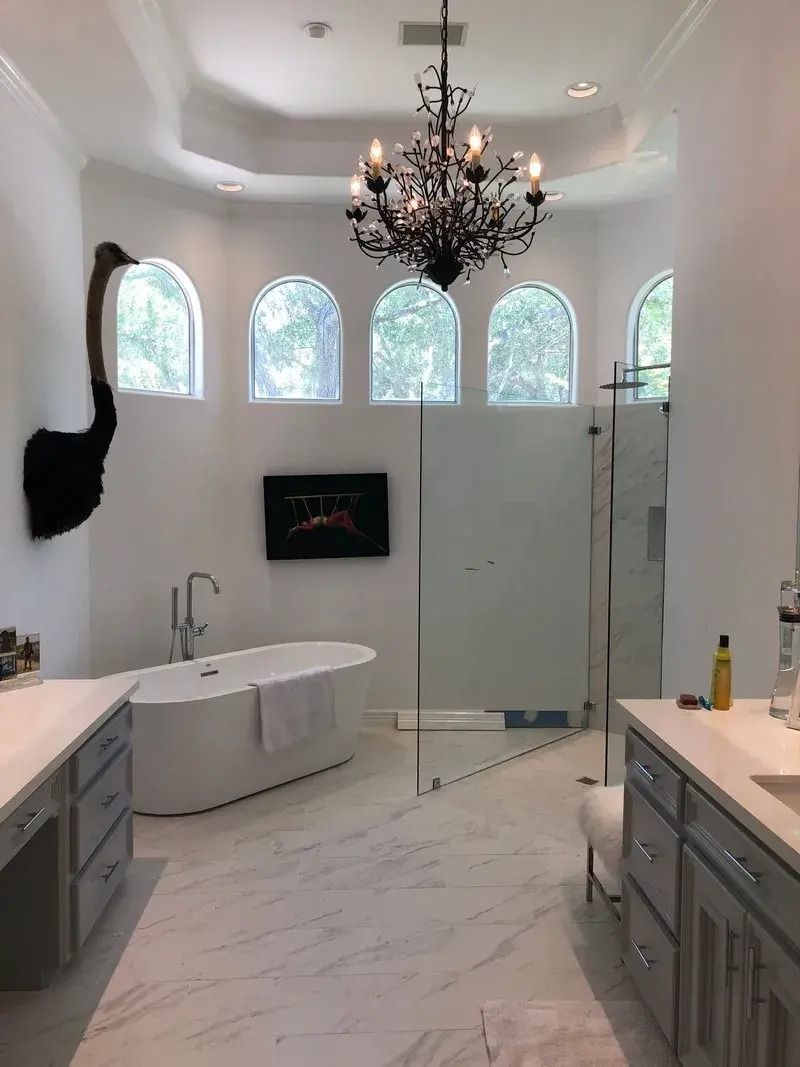 A bathroom with a bathtub and a chandelier hanging from the ceiling