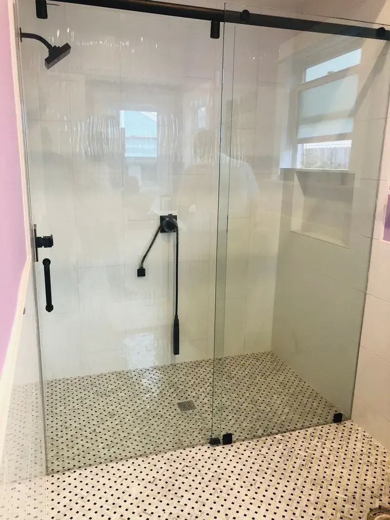 A bathroom with a sliding glass shower door.
