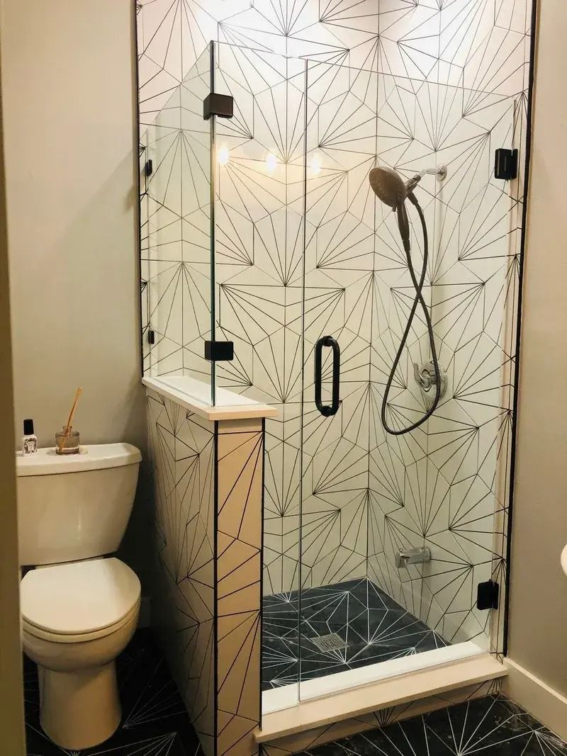 A bathroom with a toilet and a shower with a glass door.