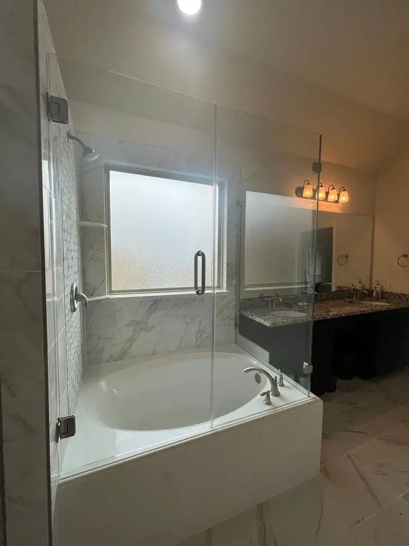 A bathroom with a tub , sink , mirror and shower.