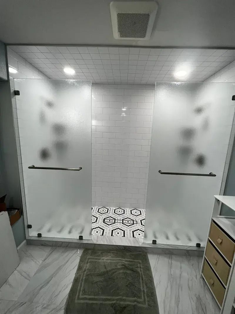 A bathroom with a walk in shower and a rug.