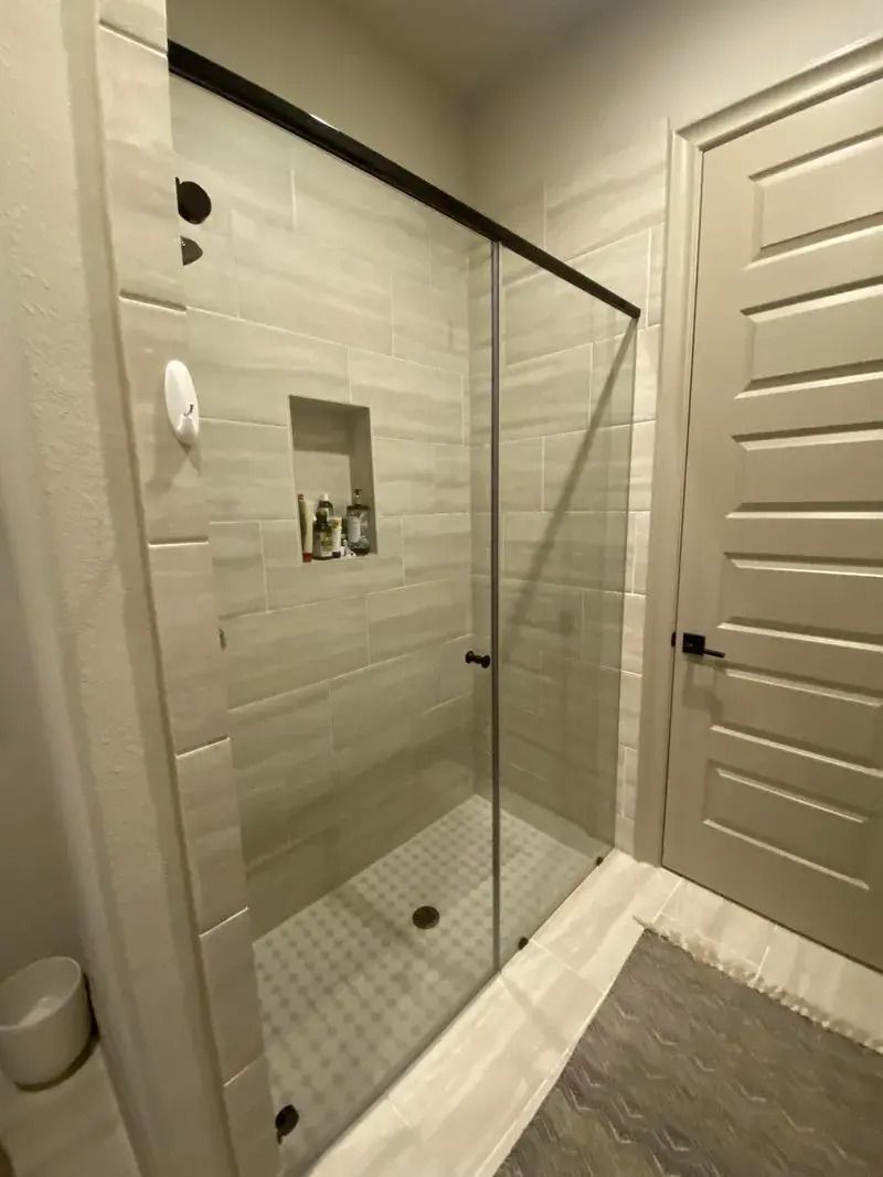 A bathroom with a sliding glass shower door.
