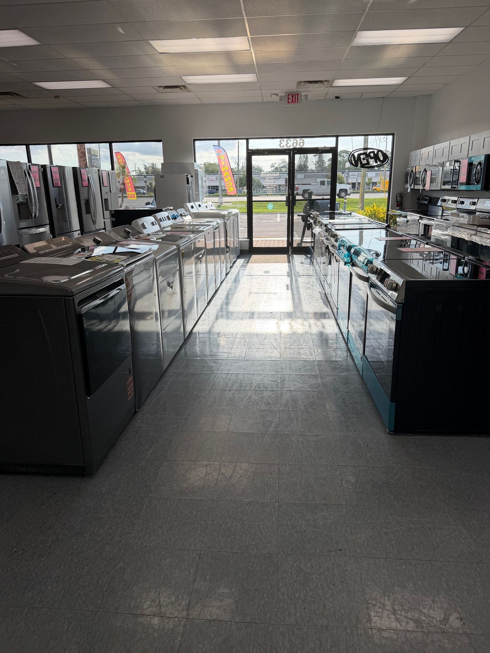 Bright retail store interior with display counters and a glass entrance at the back