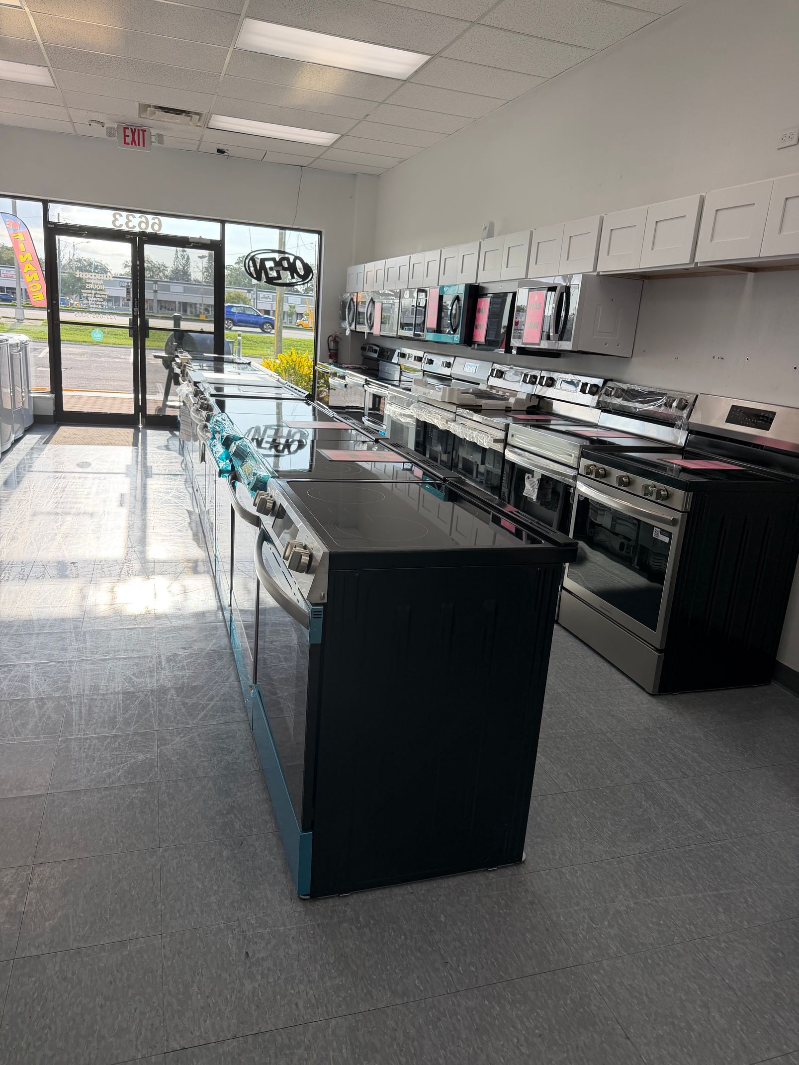 Bright retail store interior with display counters, shelves, and front glass doors.