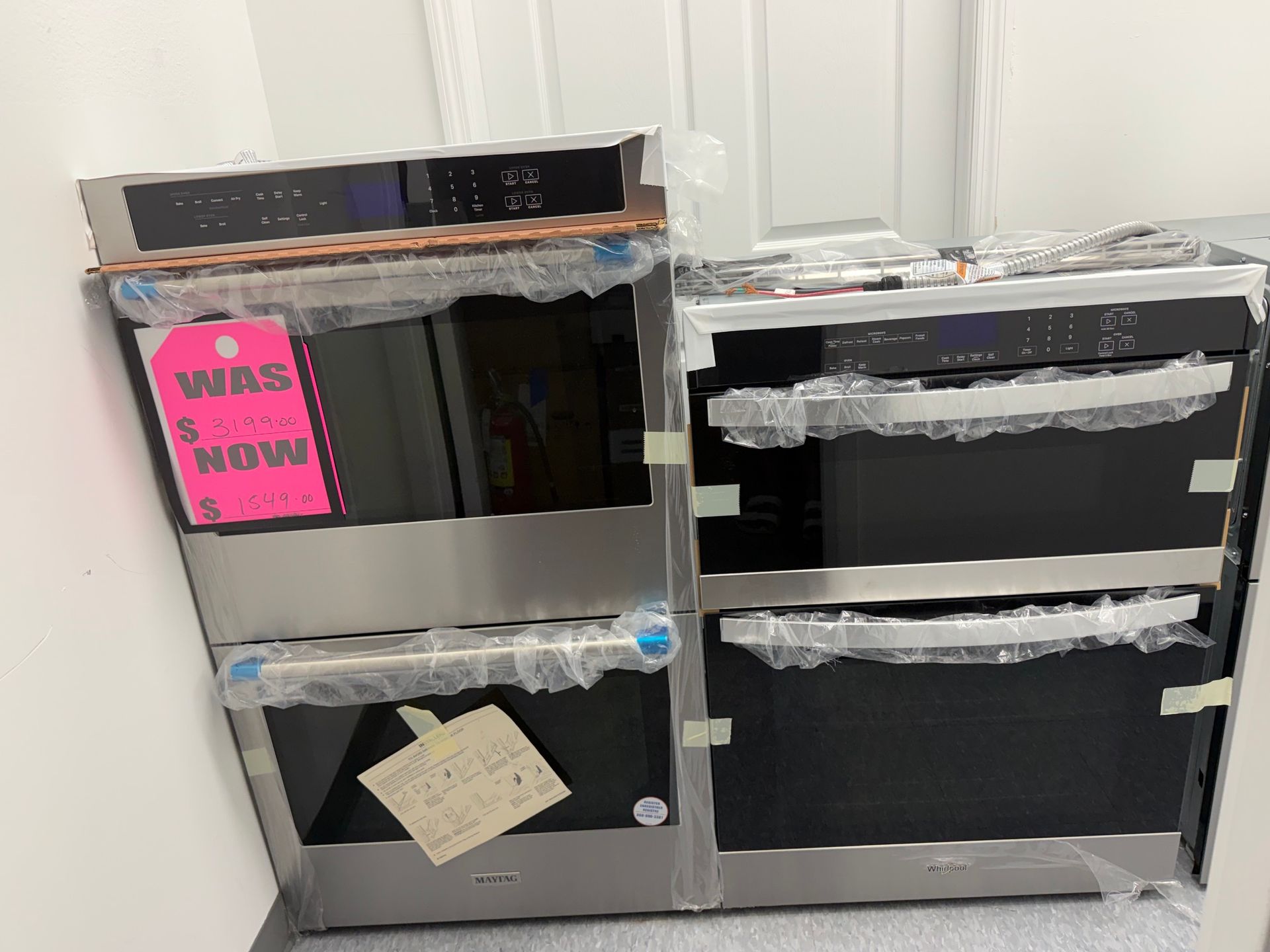 Two black cabinets taped shut in a storage room, one with a pink “We’re moving!” sign.