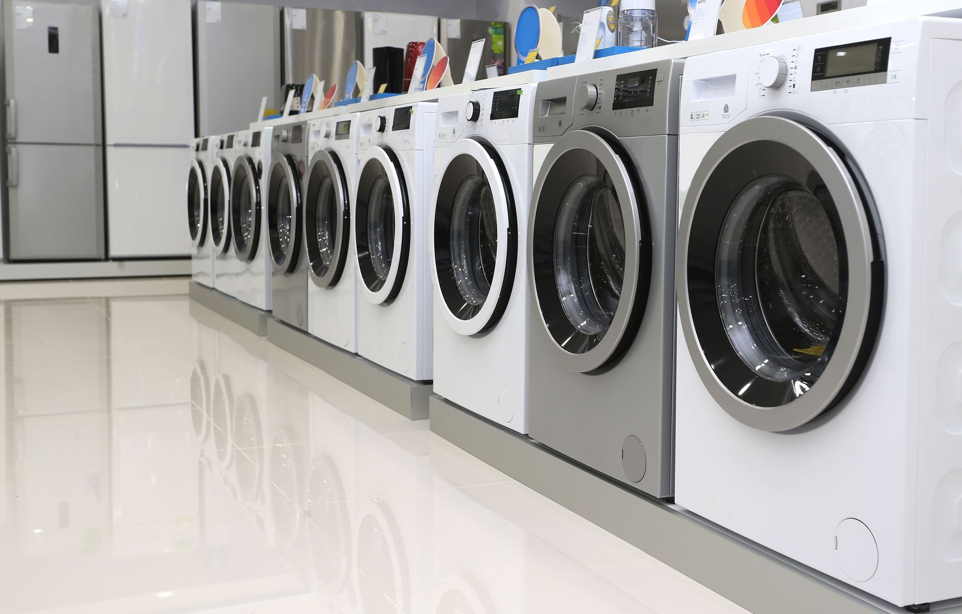 Row of front-loading washing machines in a bright laundromat aisle