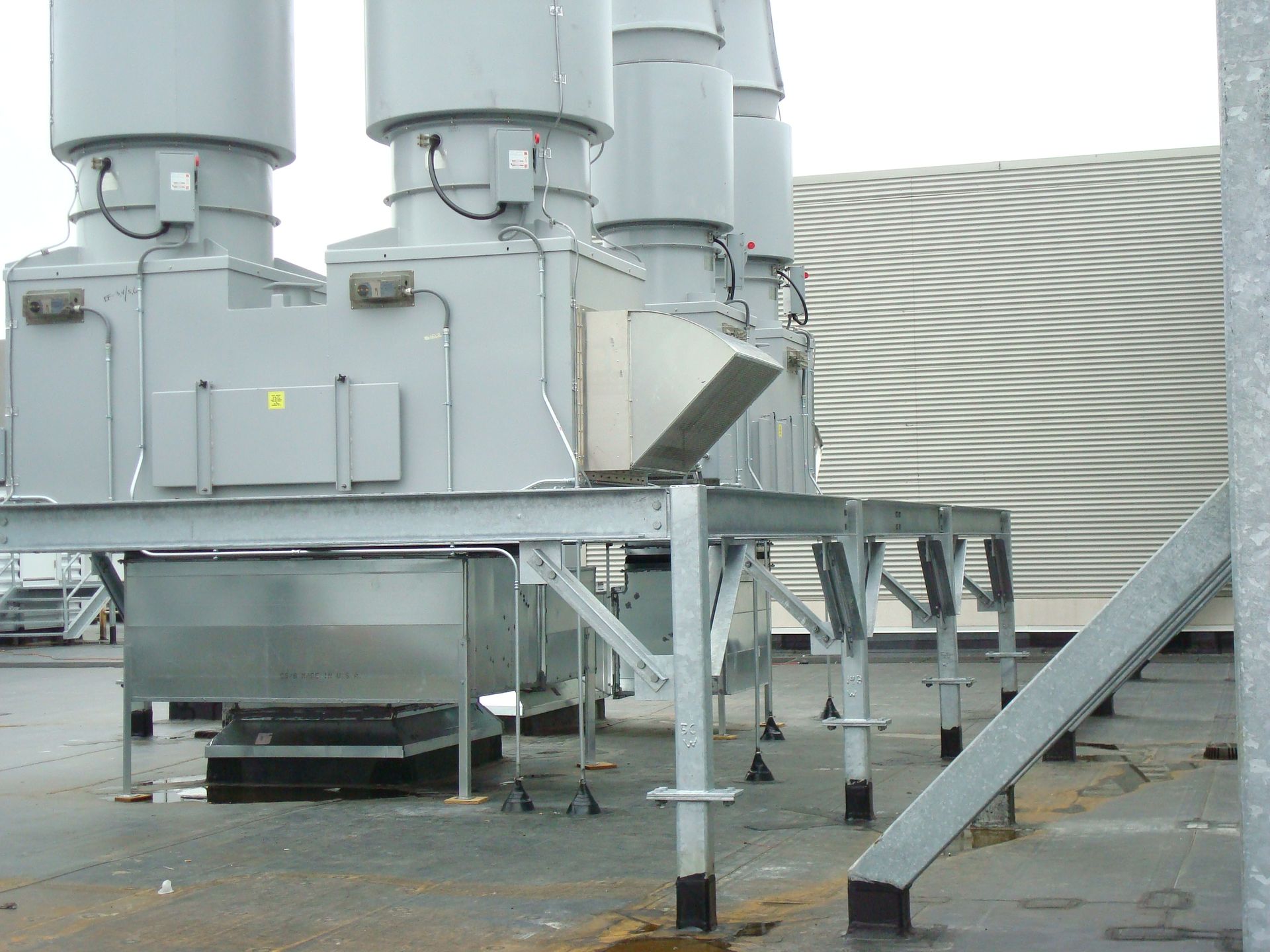 A row of gray pipes are lined up on a metal platform