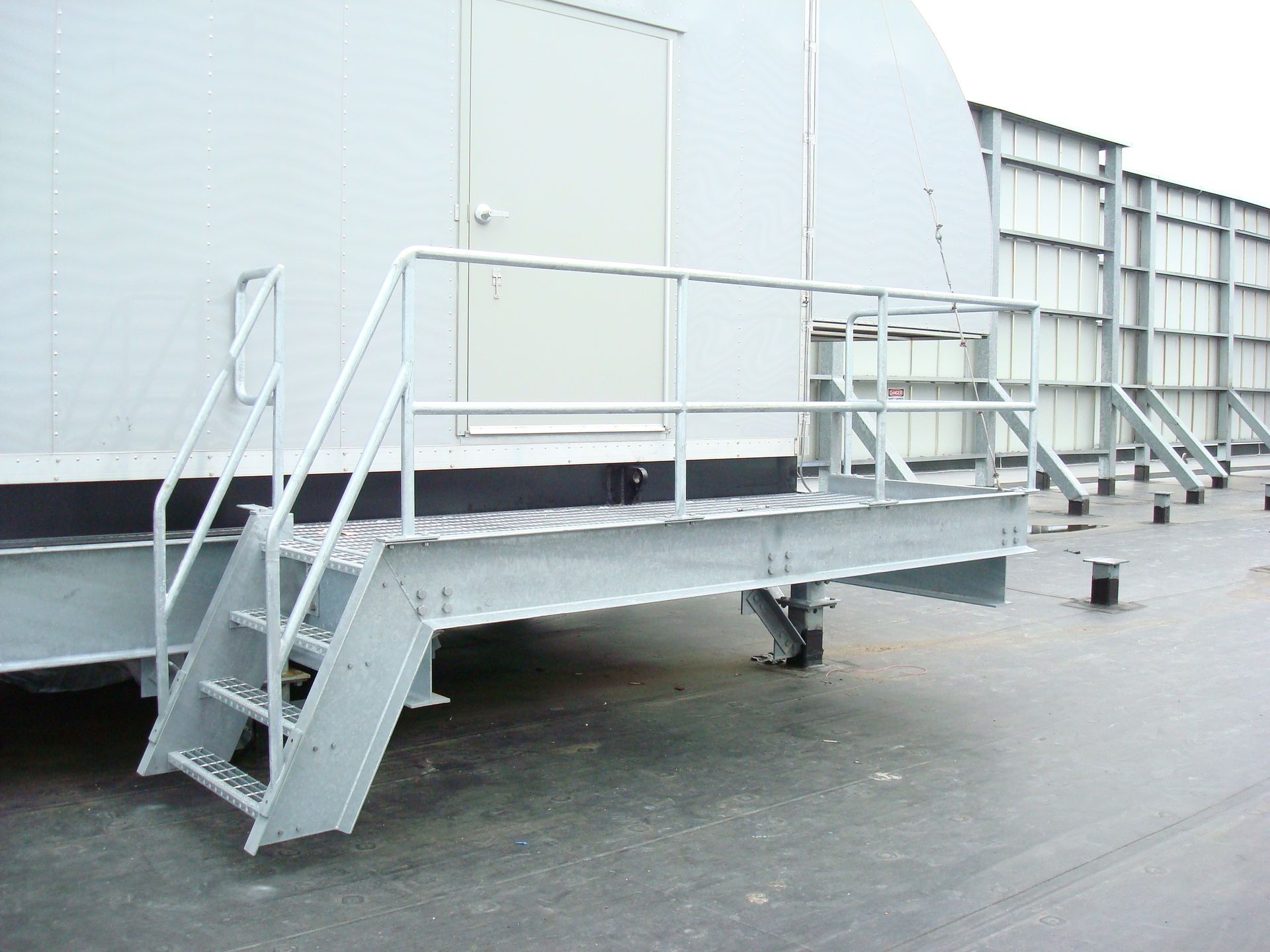 A metal platform with stairs leading up to a building