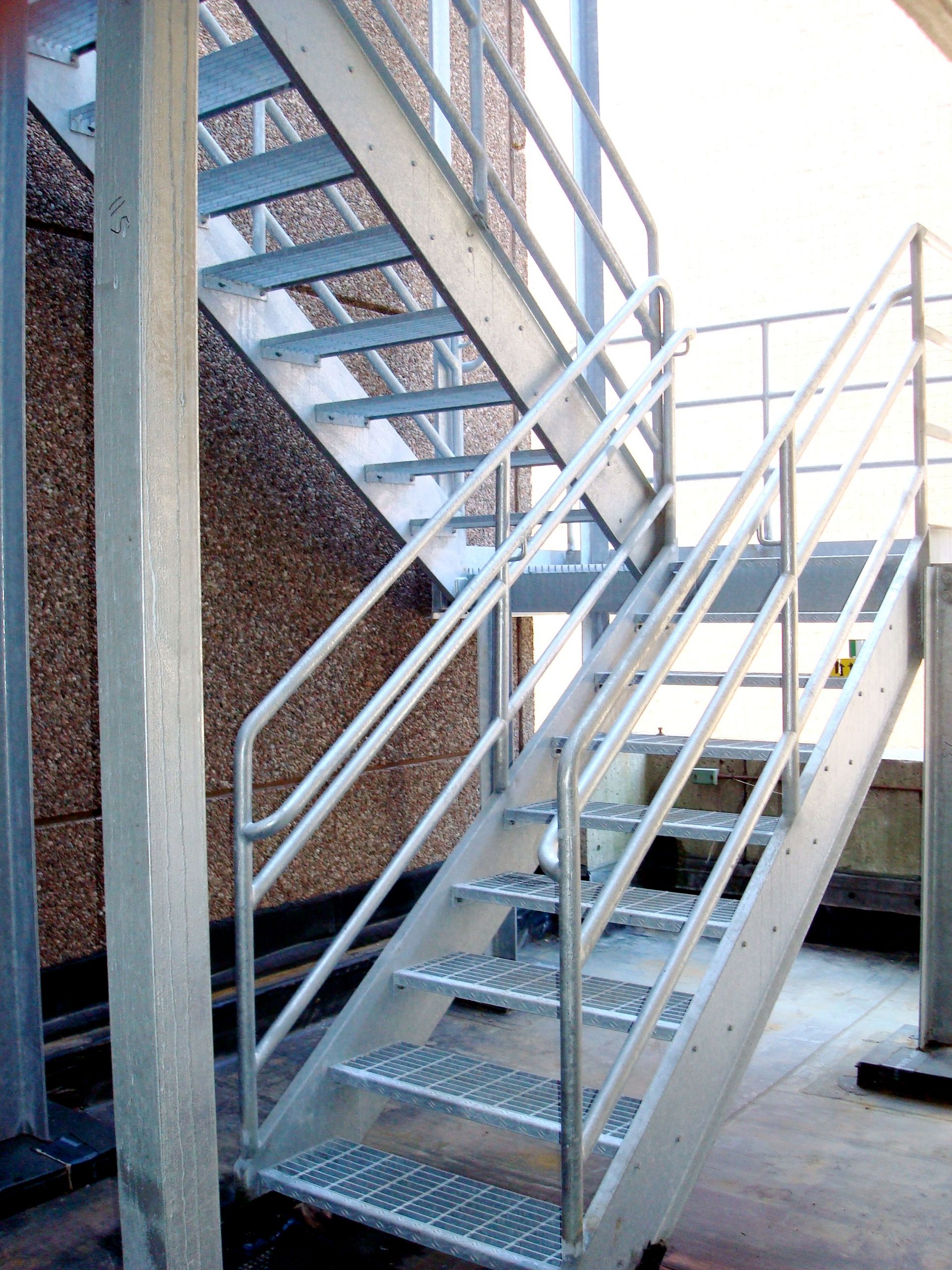 A set of stairs with a metal railing leading up to a building