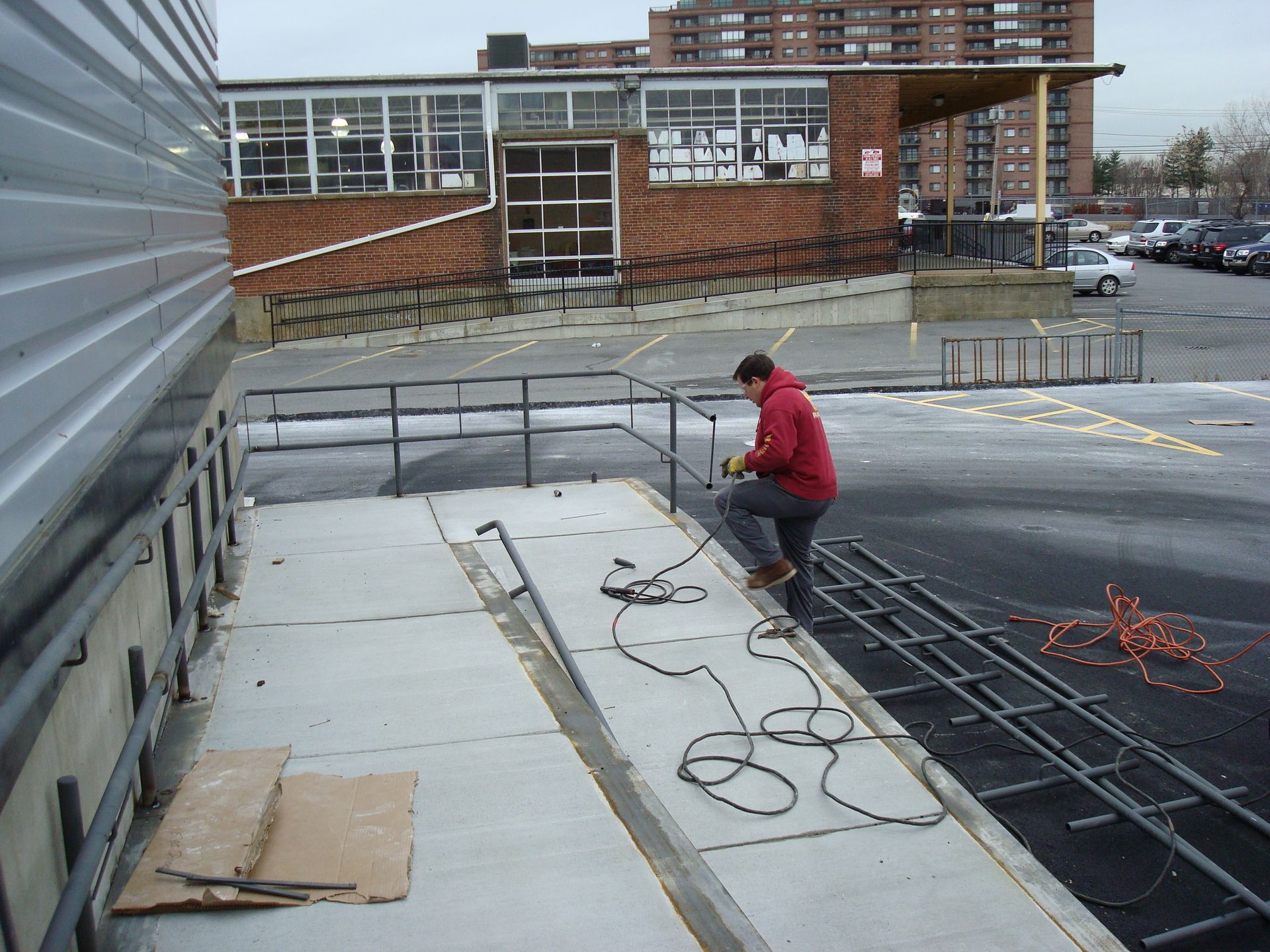 A man in a red jacket is working on a roof