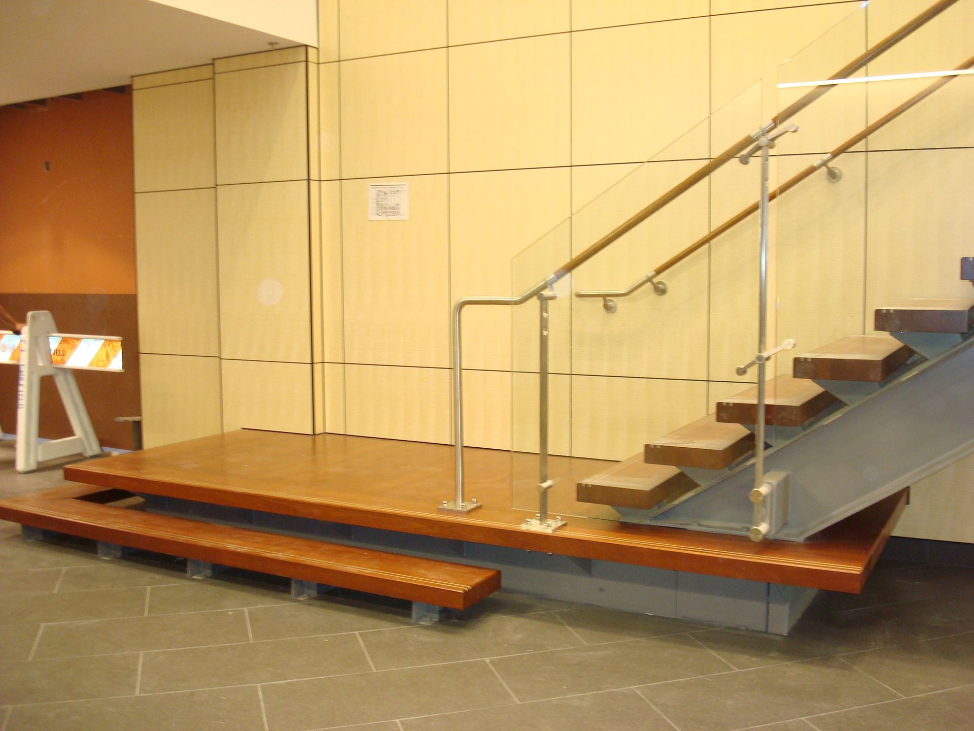 A staircase with a glass railing and wooden steps