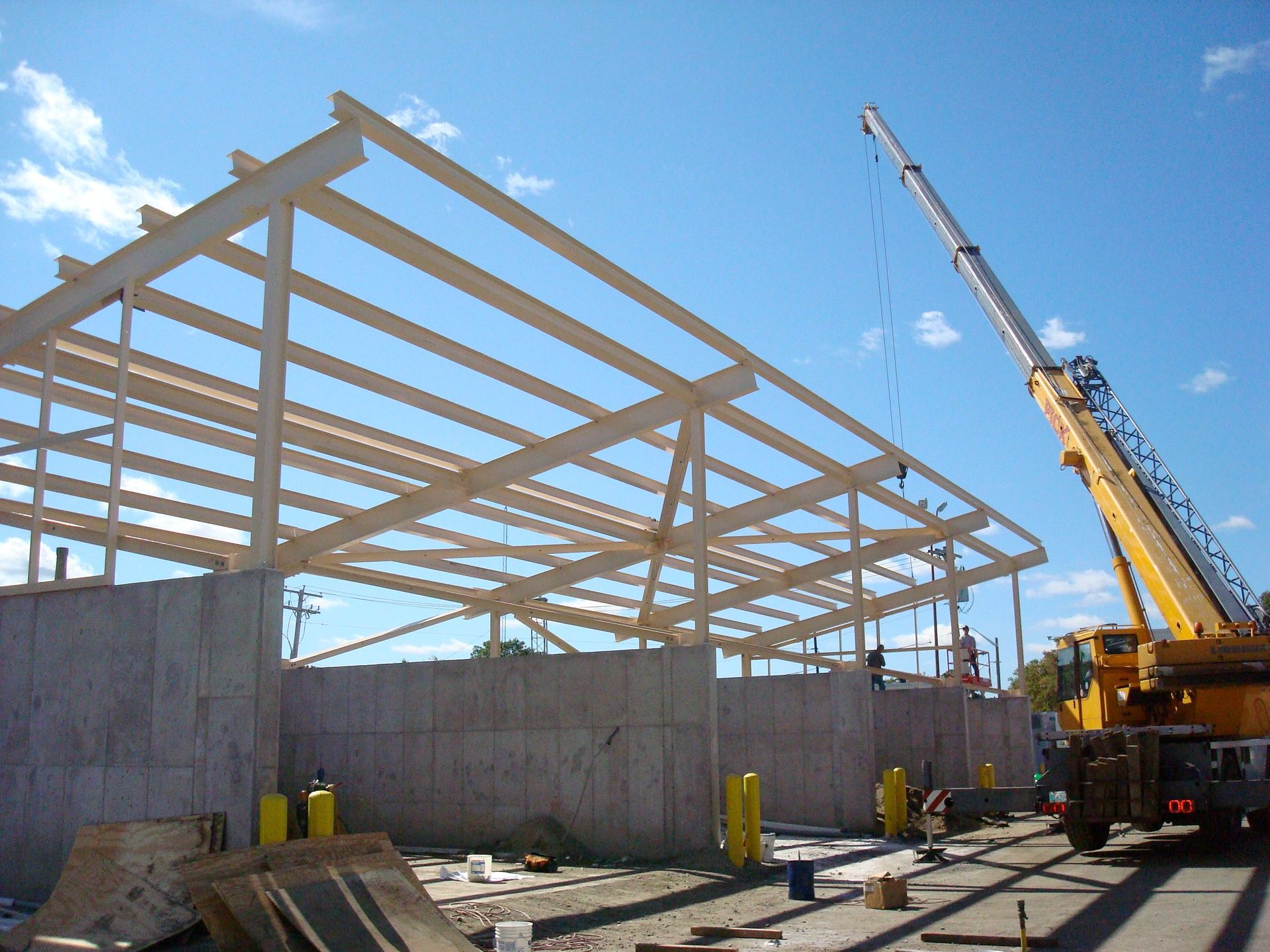 A large yellow crane is lifting a wooden structure