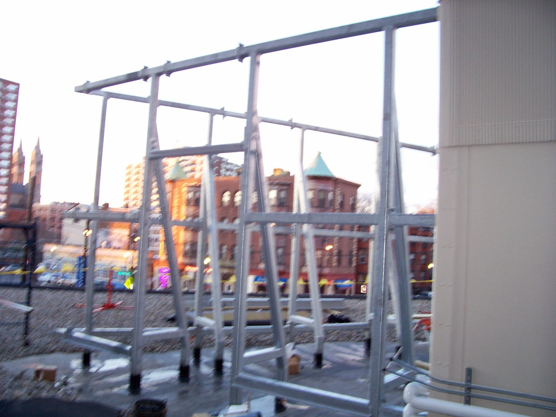 A large metal structure with a building in the background