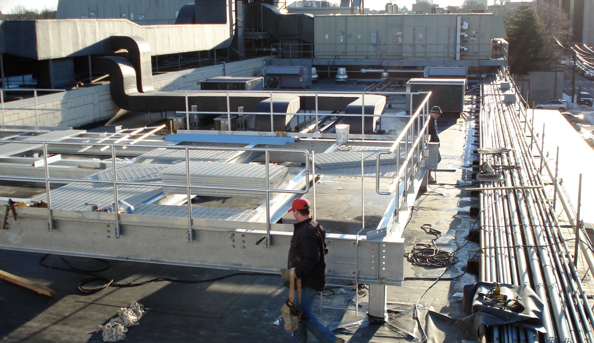 A man in a red hat is standing on the roof of a building