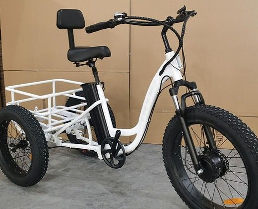 A white bicycle with three wheels and a basket on the back