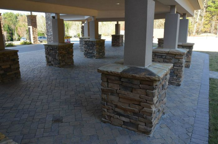 a row of stone pillars surround a brick walkway