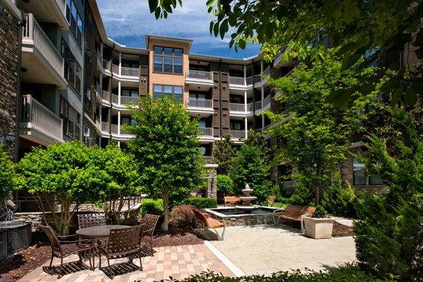 a large apartment building with a patio area in front of it