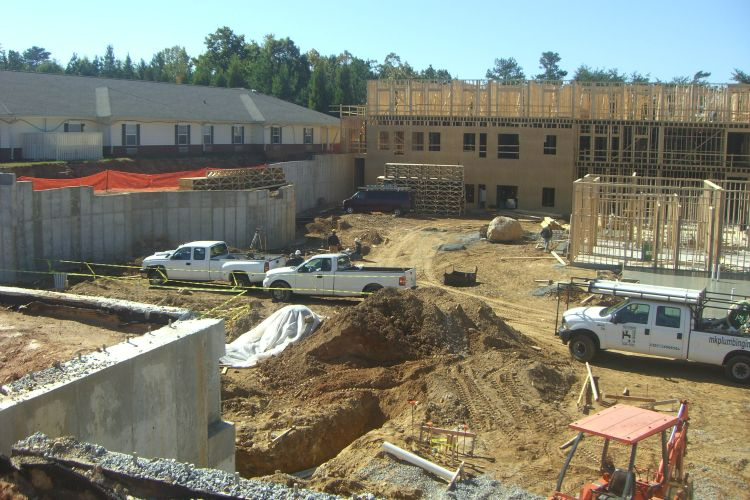 a construction site with trucks parked in front of a building under construction
